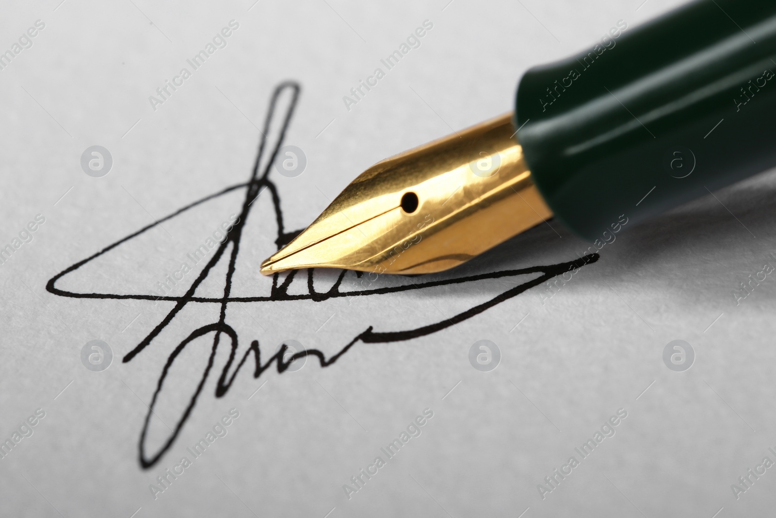 Photo of Signing on sheet of paper with fountain pen, closeup