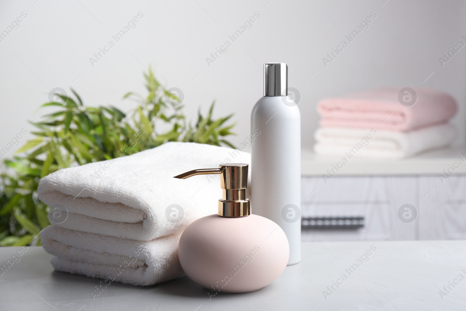 Photo of Fresh towels and toiletries on light grey stone table. Space for text