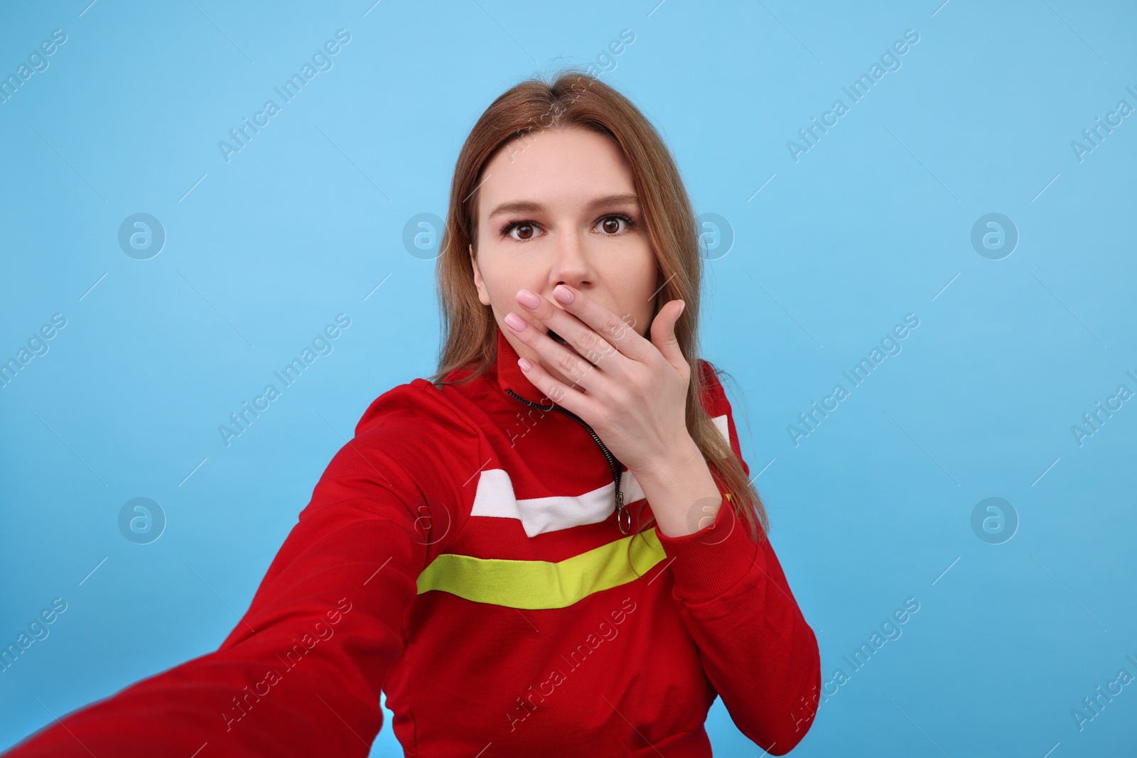 Photo of Emotional woman taking selfie on light blue background