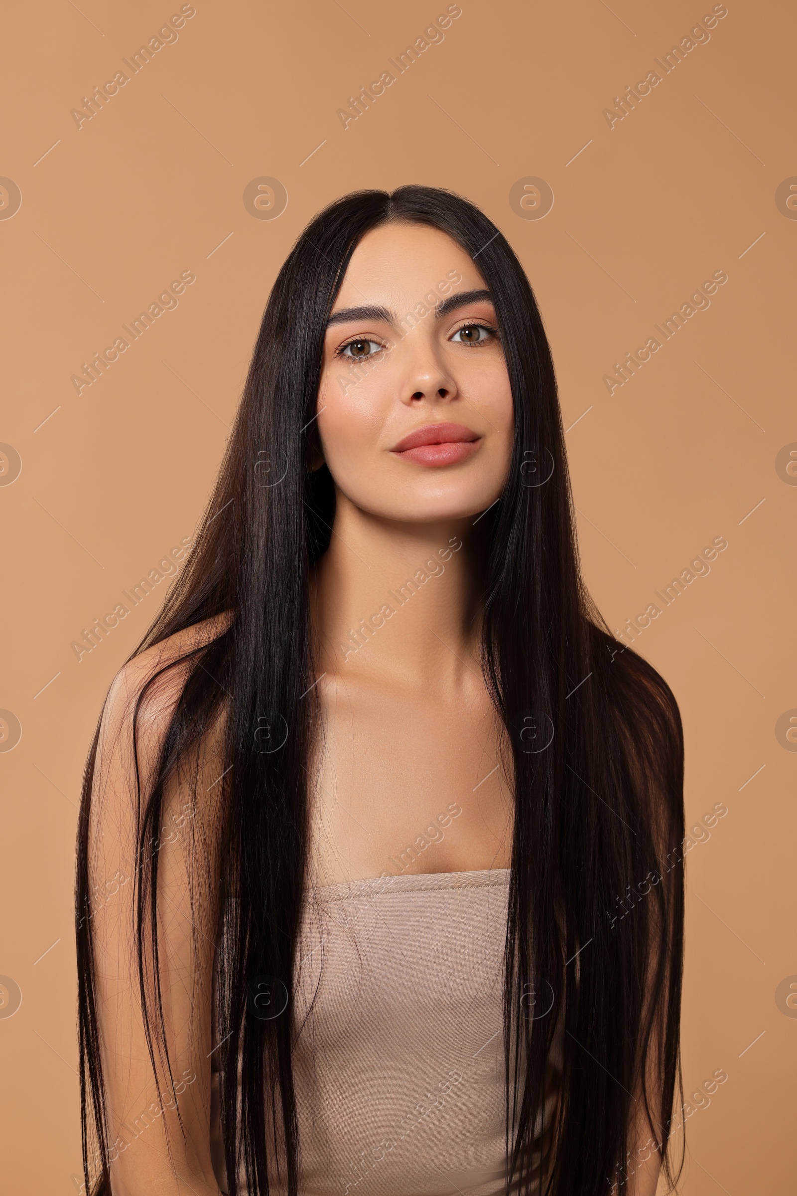 Photo of Beautiful woman with long hair on beige background