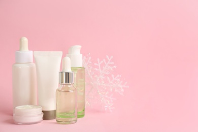 Beautiful composition with cosmetic products on pink background, space for text. Winter care