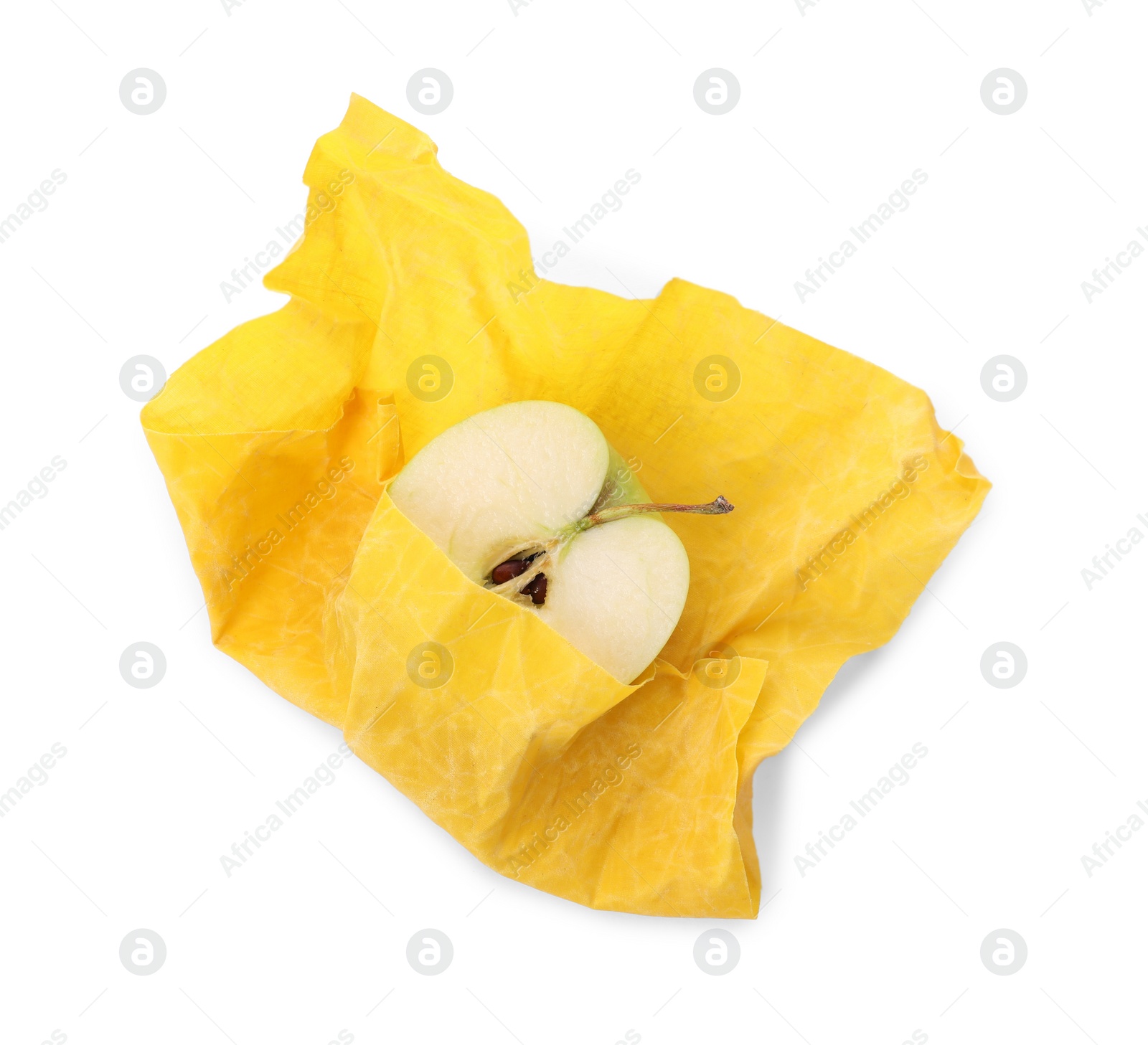 Photo of Half of apple in yellow beeswax food wrap on white background, top view