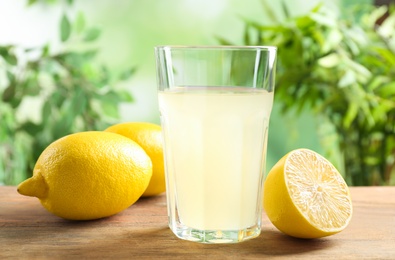 Freshly squeezed lemon juice in glass on wooden table