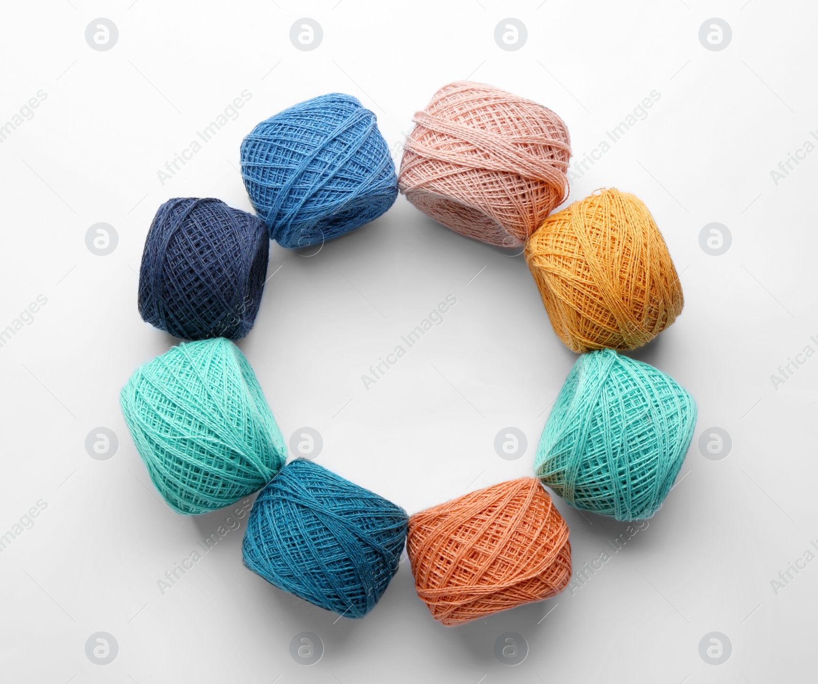 Photo of Frame made with clews of colorful knitting threads on white background, top view