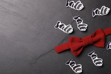 Photo of Bow tie, words Sale and space for text on dark background, flat lay. Black Friday concept