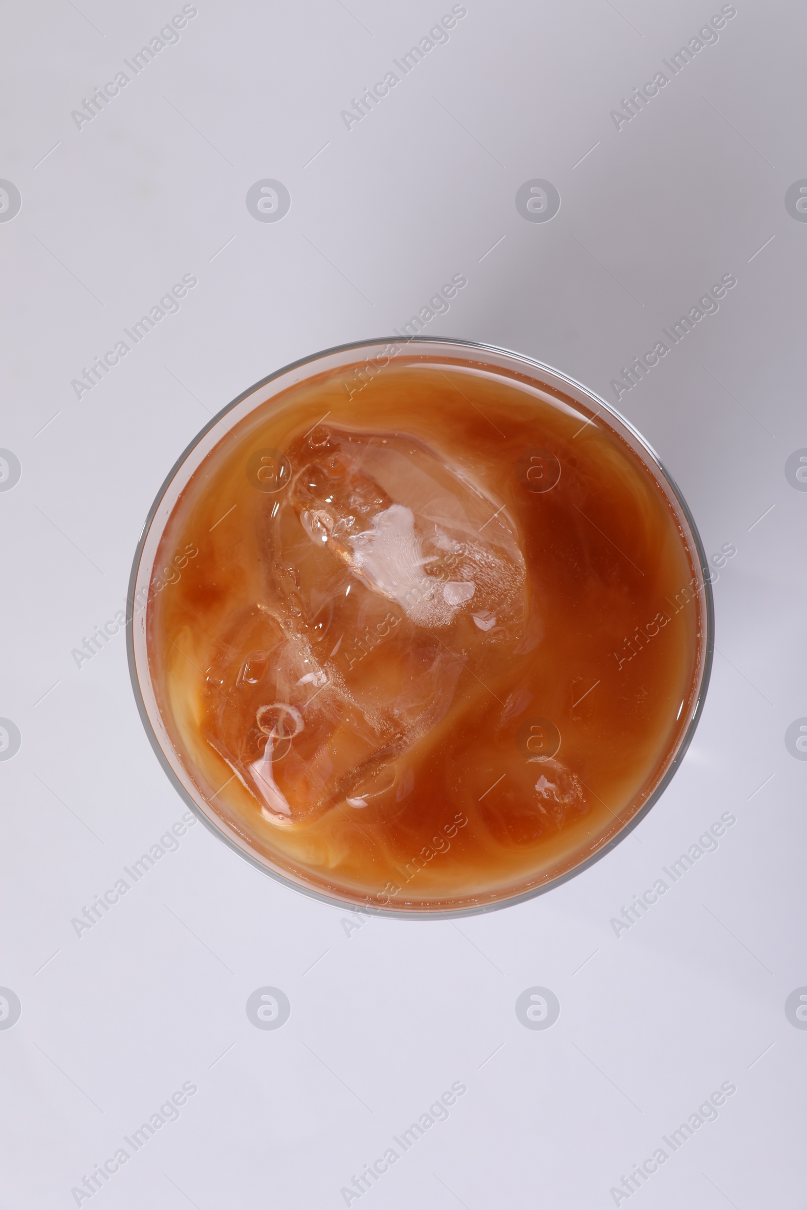 Photo of Glass of iced coffee on white table, top view