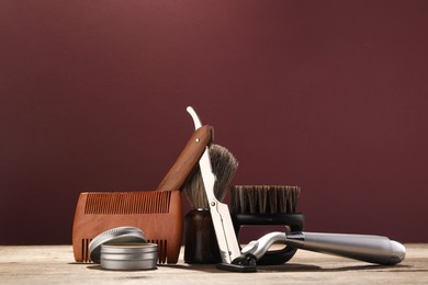 Photo of Moustache and beard styling tools on wooden table