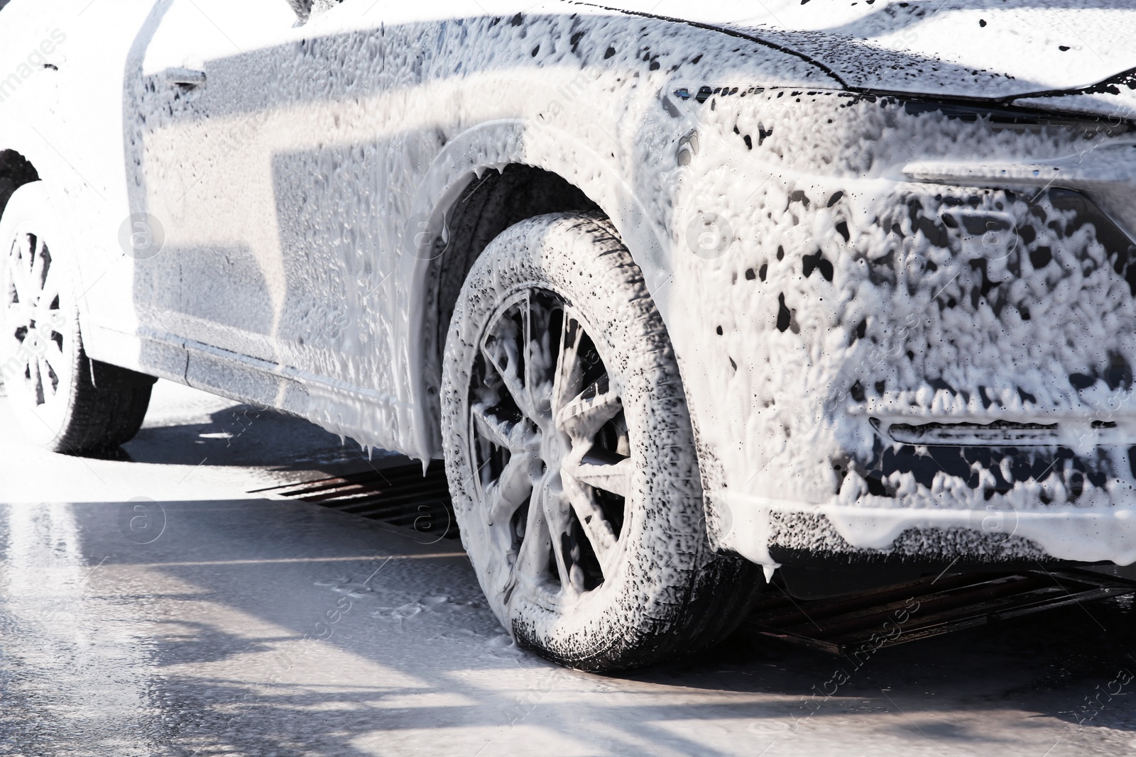 Photo of Modern automobile covered with foam at car wash