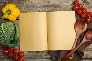 Photo of Recipe book surrounded by different ingredients on wooden table, flat lay with space for text. Cooking classes