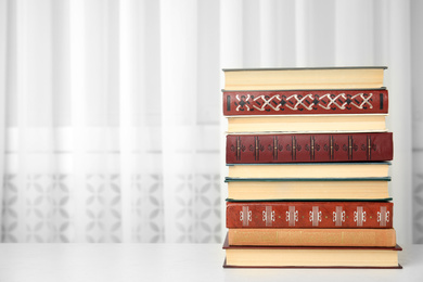 Collection of different books on table indoors. Space for text