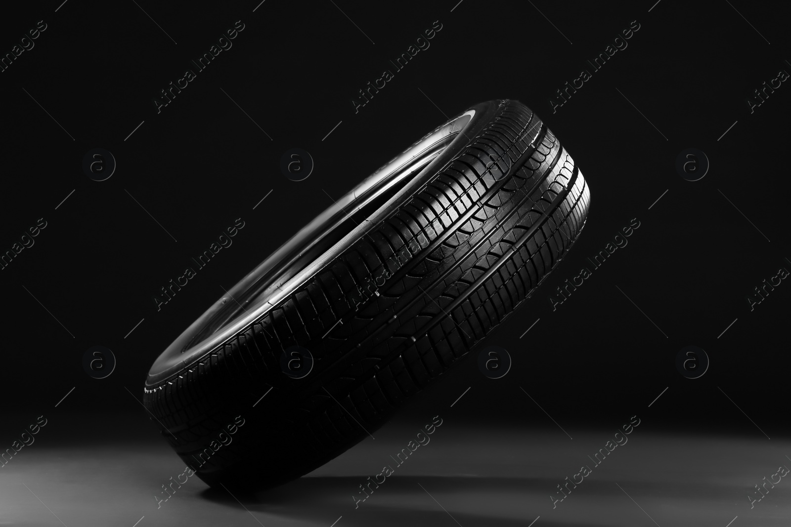 Photo of New car tire on black background