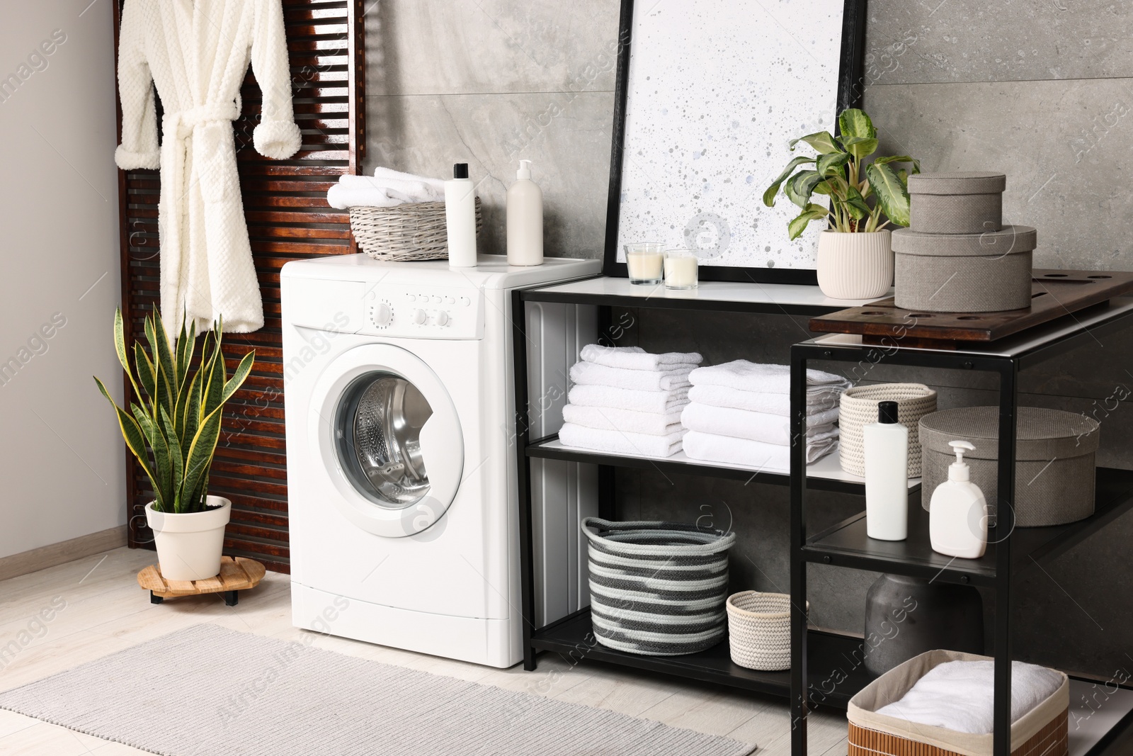 Photo of Stylish laundry room with modern washing machine. Interior design