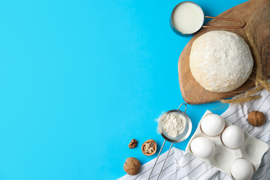 Flat lay composition with dough on blue background, space for text. Cooking pastries