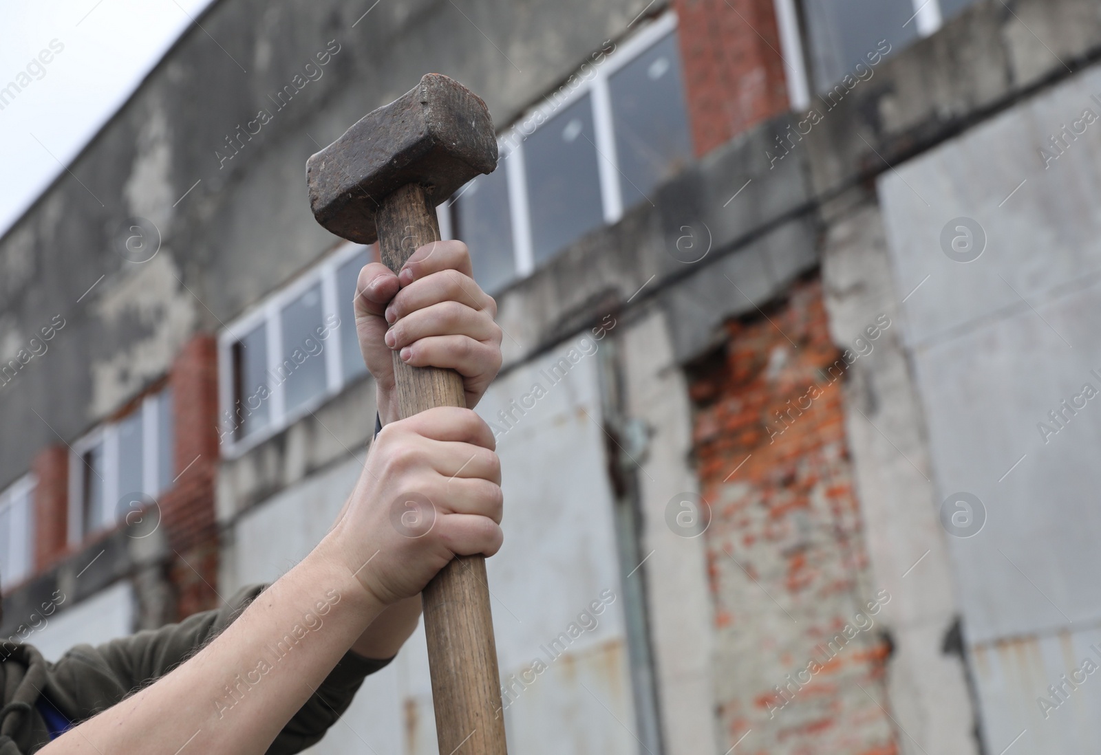 Photo of Man with sledgehammer outdoors, closeup. Space for text