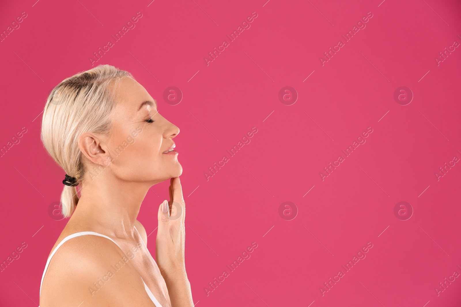 Photo of Portrait of beautiful mature woman on pink background. Space for text