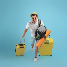 Photo of Male tourist with travel backpack and suitcases running on turquoise background