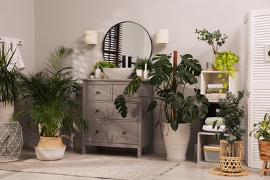 Photo of Stylish bathroom interior with modern furniture and beautiful green houseplants