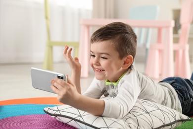 Little boy using video chat on smartphone in playroom