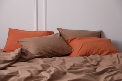 Photo of Bed with orange and brown linens in stylish room