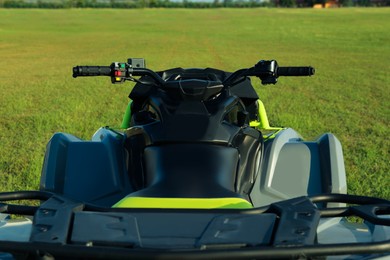 Photo of Modern quad bike in field on sunny day, closeup