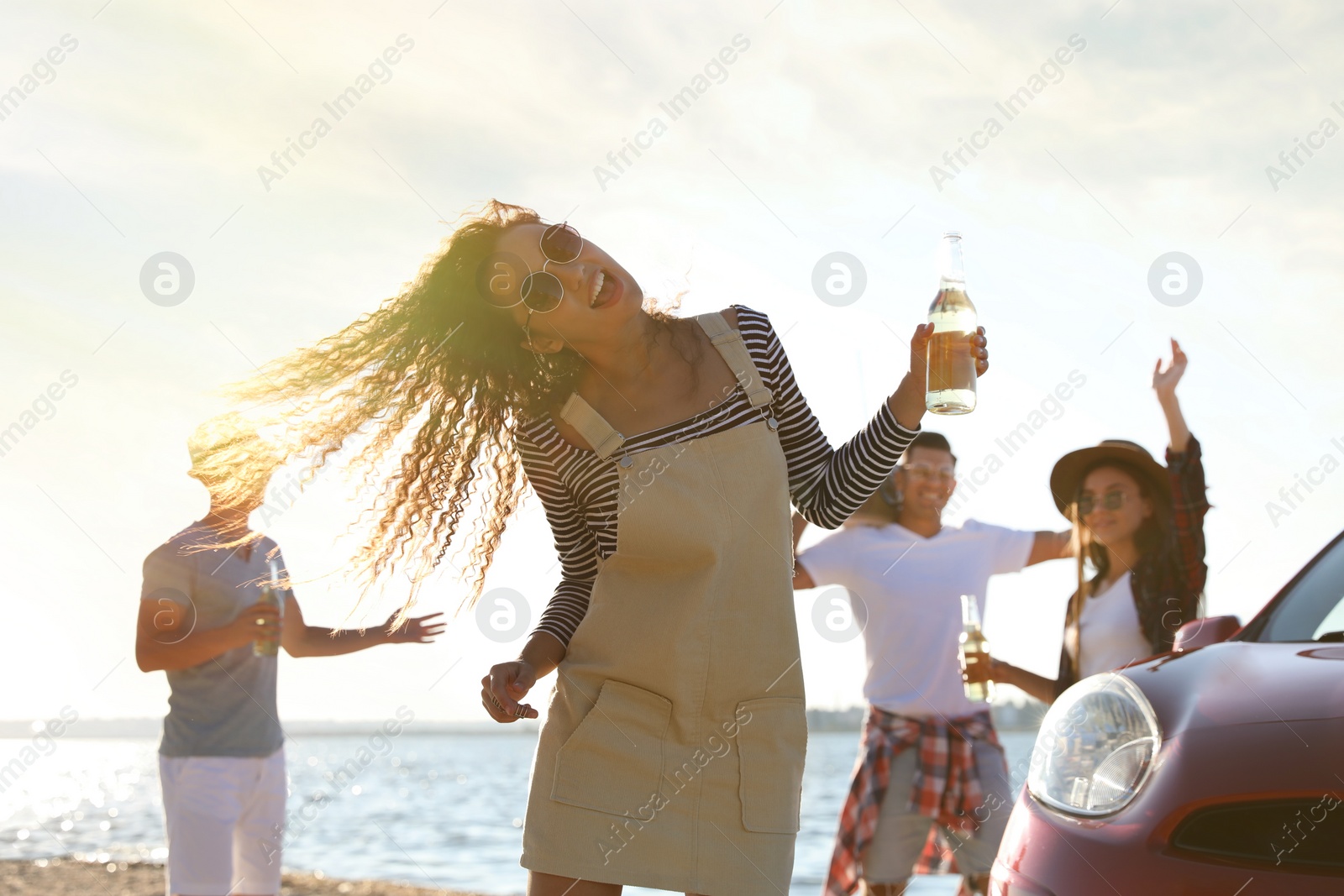 Photo of Happy friends having fun near car on beach. Summer trip