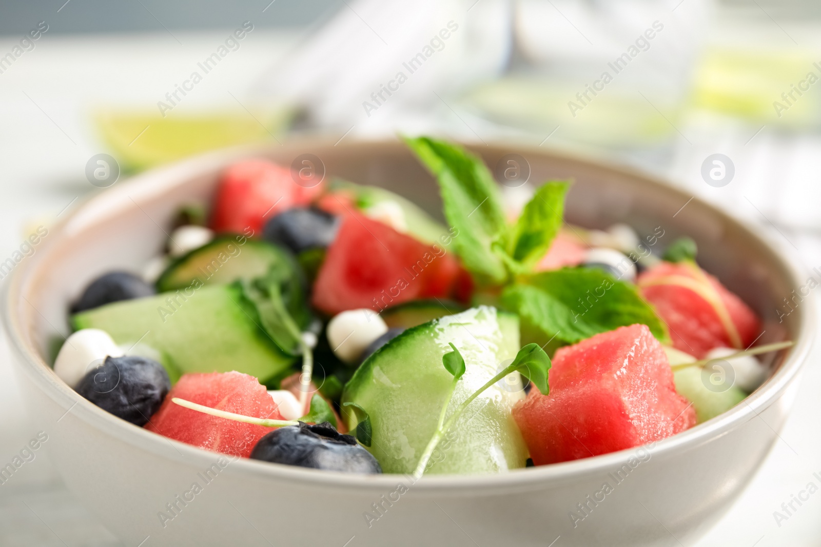 Photo of Delicious salad with watermelon served in bowl, closeup