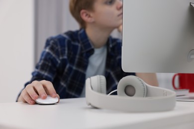 Teenage boy using computer in room, focus on hand. Internet addiction