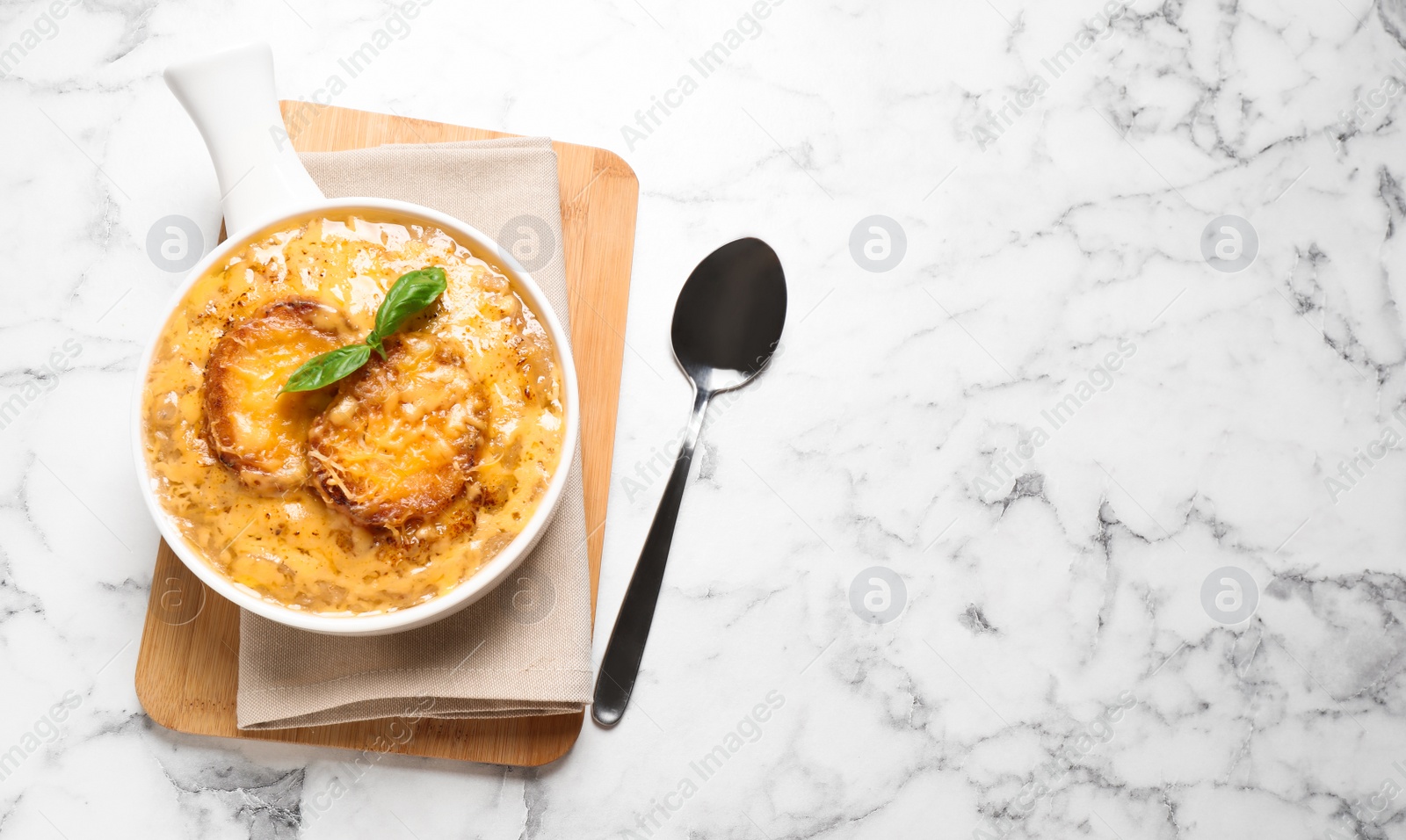 Photo of Tasty homemade french onion soup served on white marble table, flat lay. Space for text