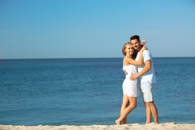 Happy young couple at beach on sunny day