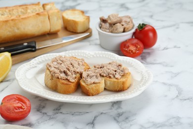 Photo of Tasty sandwiches with cod liver on white marble table