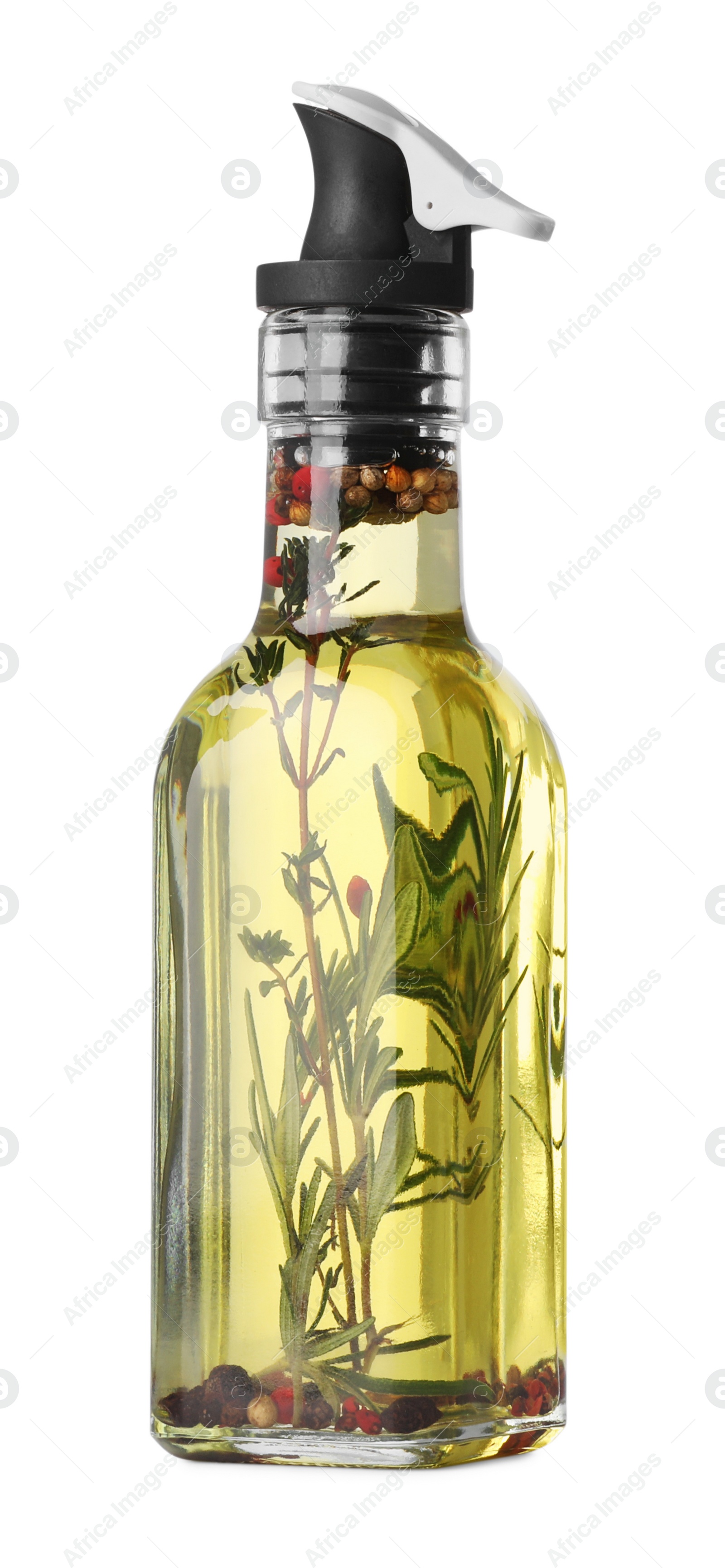 Photo of Glass bottle of cooking oil with spices and herbs isolated on white