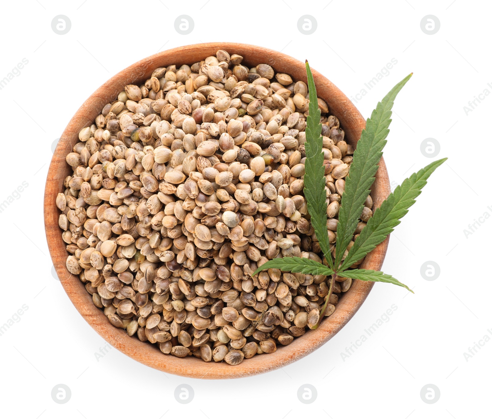 Photo of Wooden bowl of hemp seeds and leaf on white background, top view