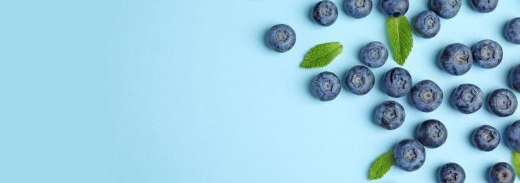 Image of Tasty fresh blueberries on light blue background, flat lay with space for text. Banner design