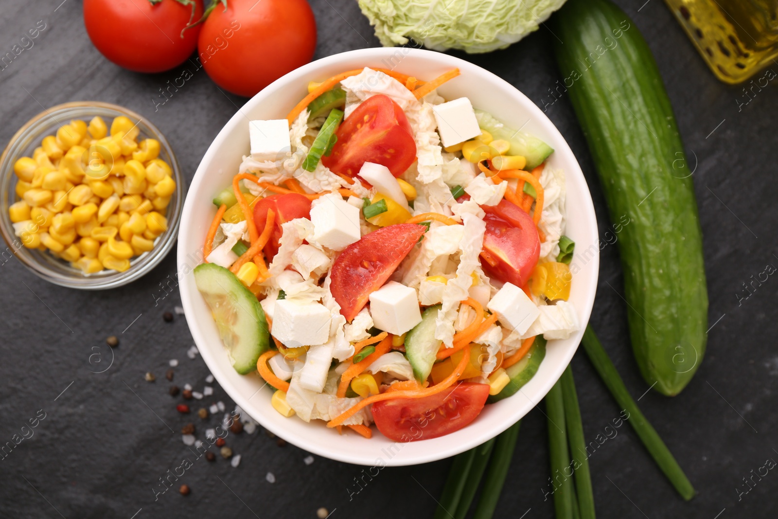 Photo of Tasty salad with Chinese cabbage served on black table, flat lay