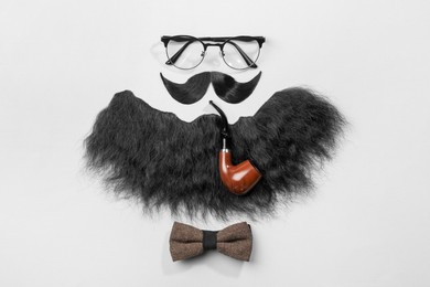 Flat lay composition with artificial moustache and glasses on light grey background