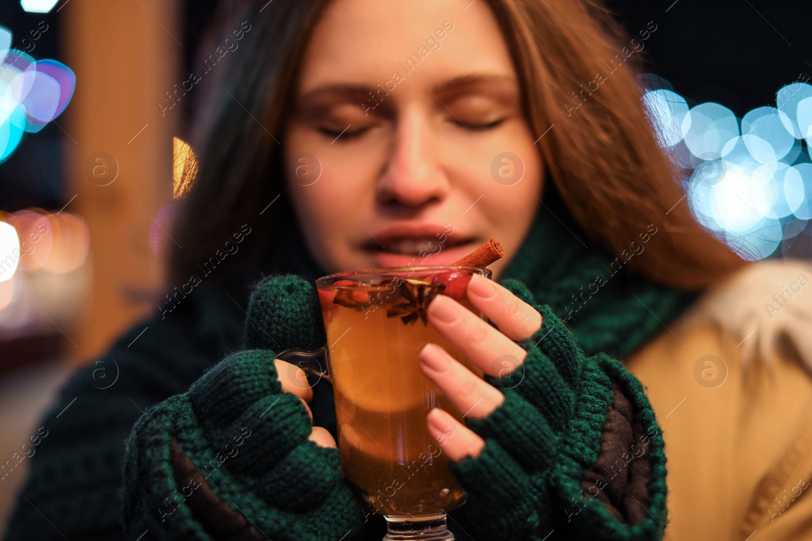 Photo of Happy woman with tasty mulled wine at winter fair