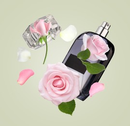 Bottle of perfume and roses in air on pale olive background. Flower fragrance