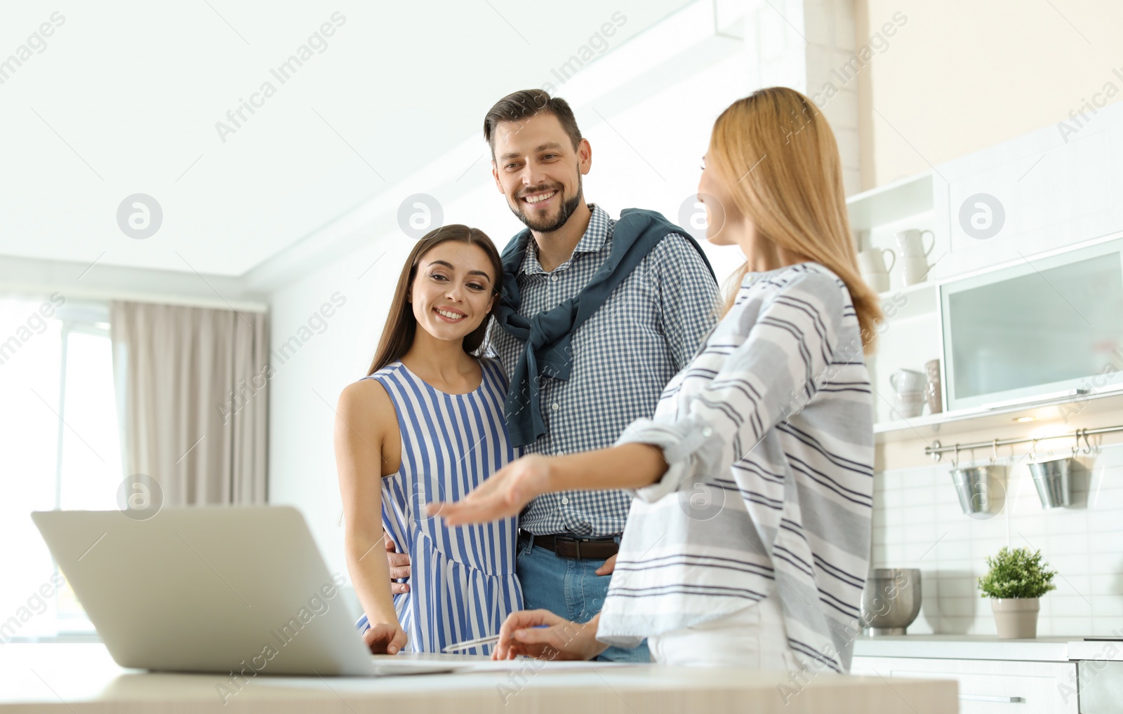 Photo of Female real estate agent working with couple, indoors