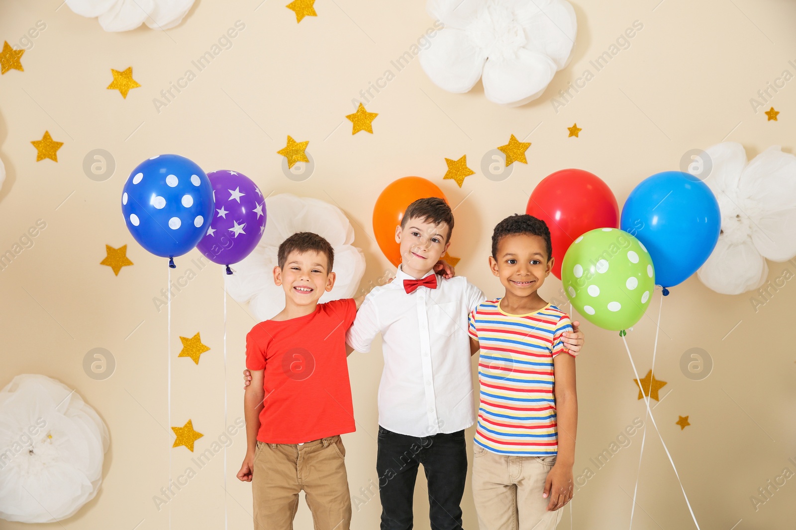 Photo of Adorable little boys and decor for birthday party on color background