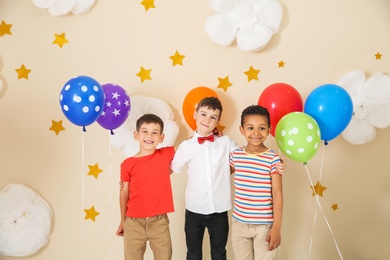 Adorable little boys and decor for birthday party on color background