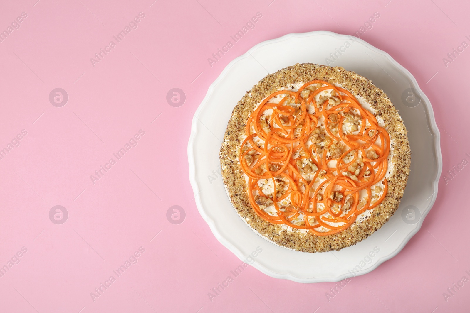 Photo of Dish with delicious carrot cake on color background, top view. Space for text