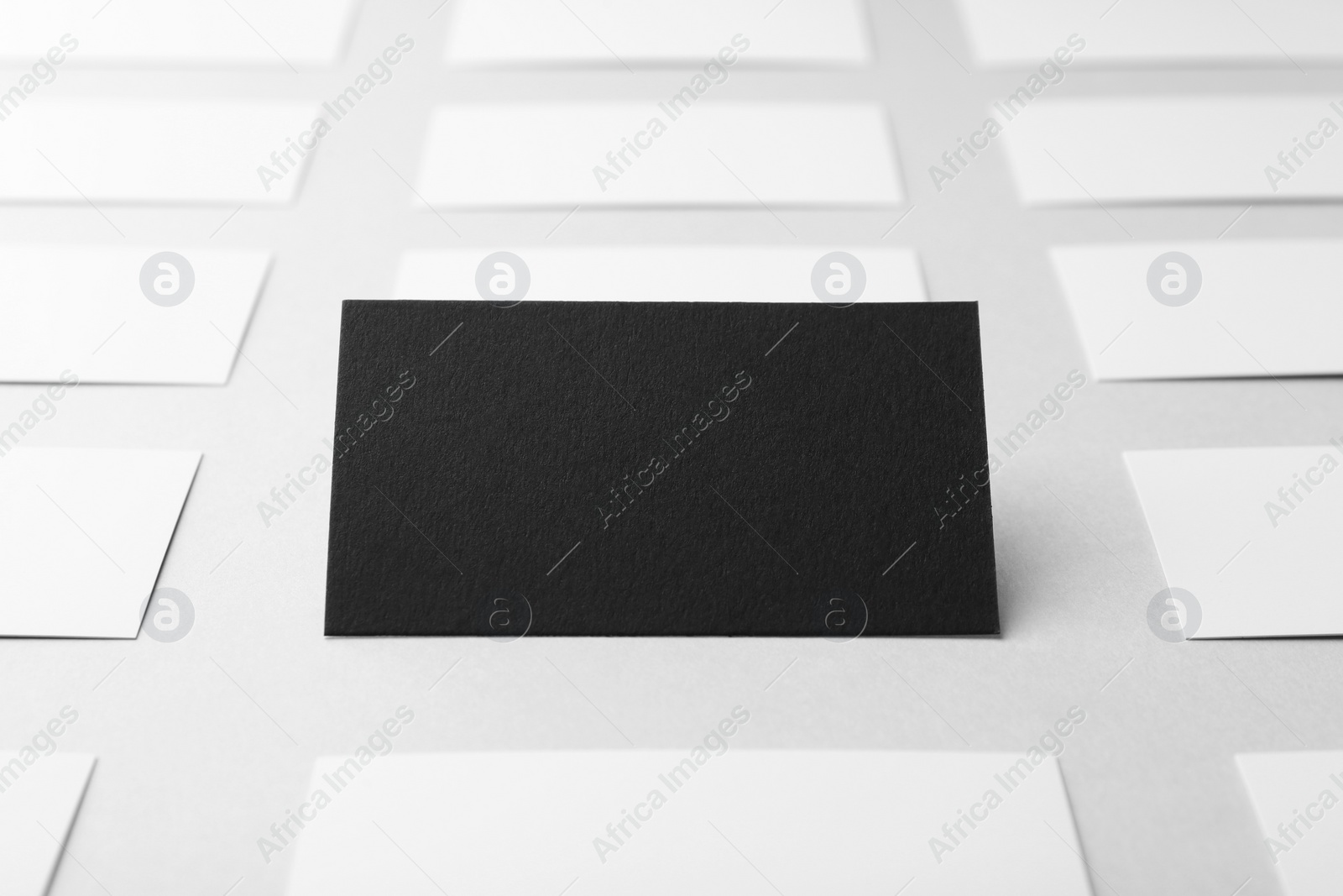 Photo of Blank black and white business cards on light background, closeup. Mockup for design