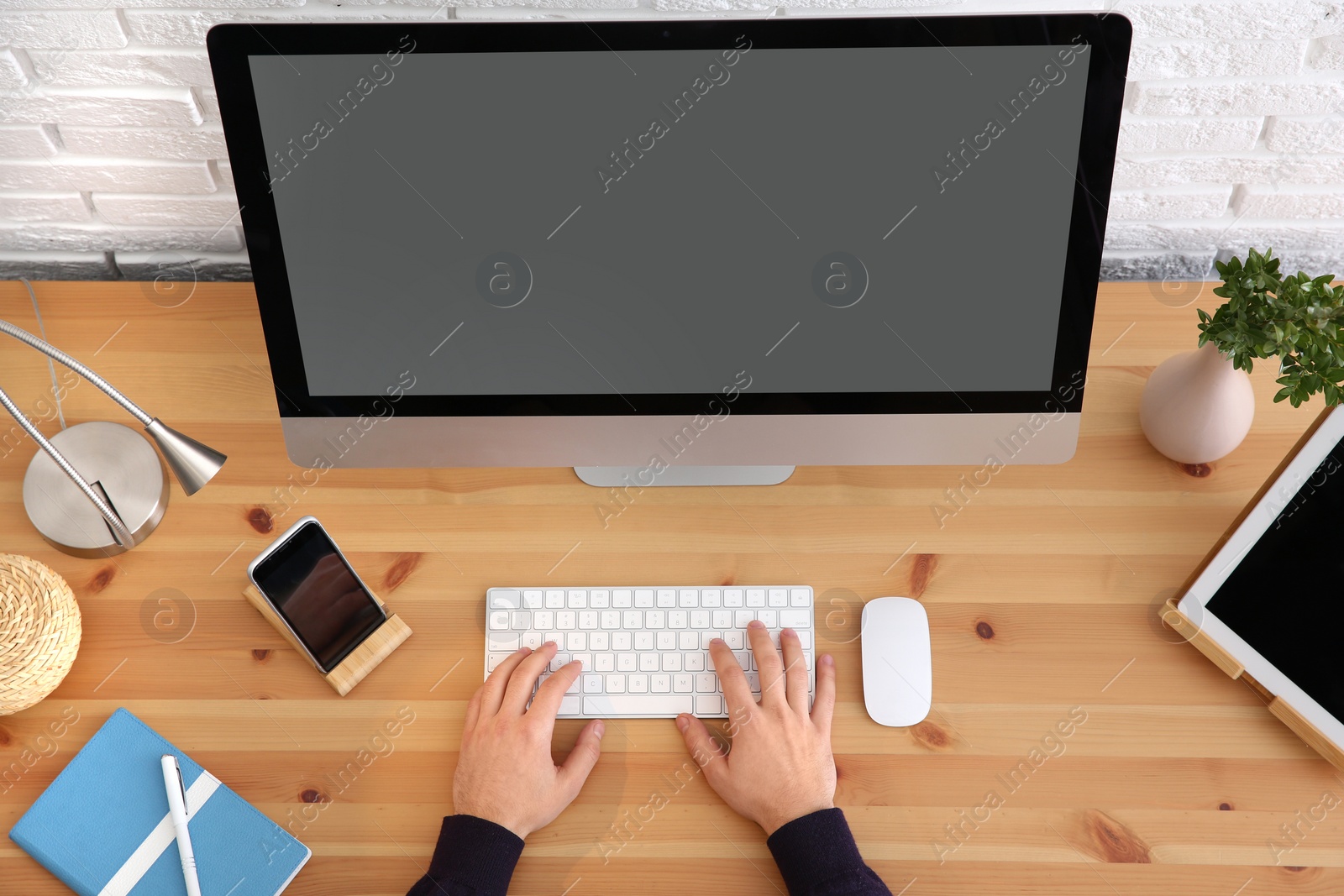 Photo of Young man using modern computer at table, top view