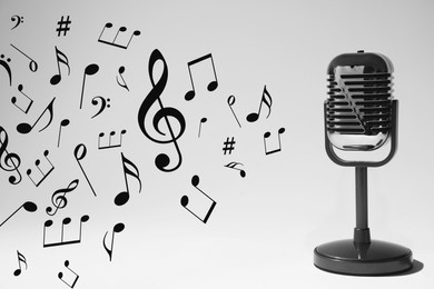 Image of Music notes and other musical symbols flowing from retro microphone on light background