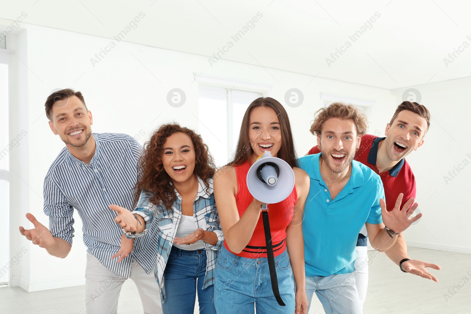Photo of Group of happy young people with megaphone indoors