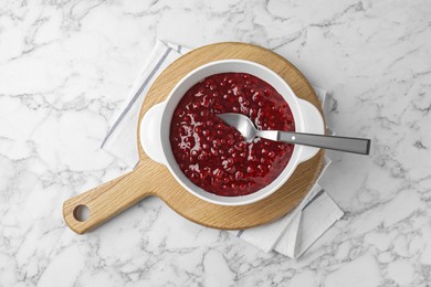 Photo of Fresh cranberry sauce in bowl served on white marble table, top view