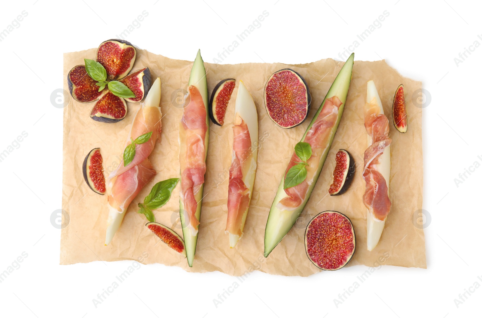 Photo of Parchment with tasty melon, jamon and figs isolated on white, top view