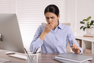 Photo of Woman coughing at table in office. Cold symptoms