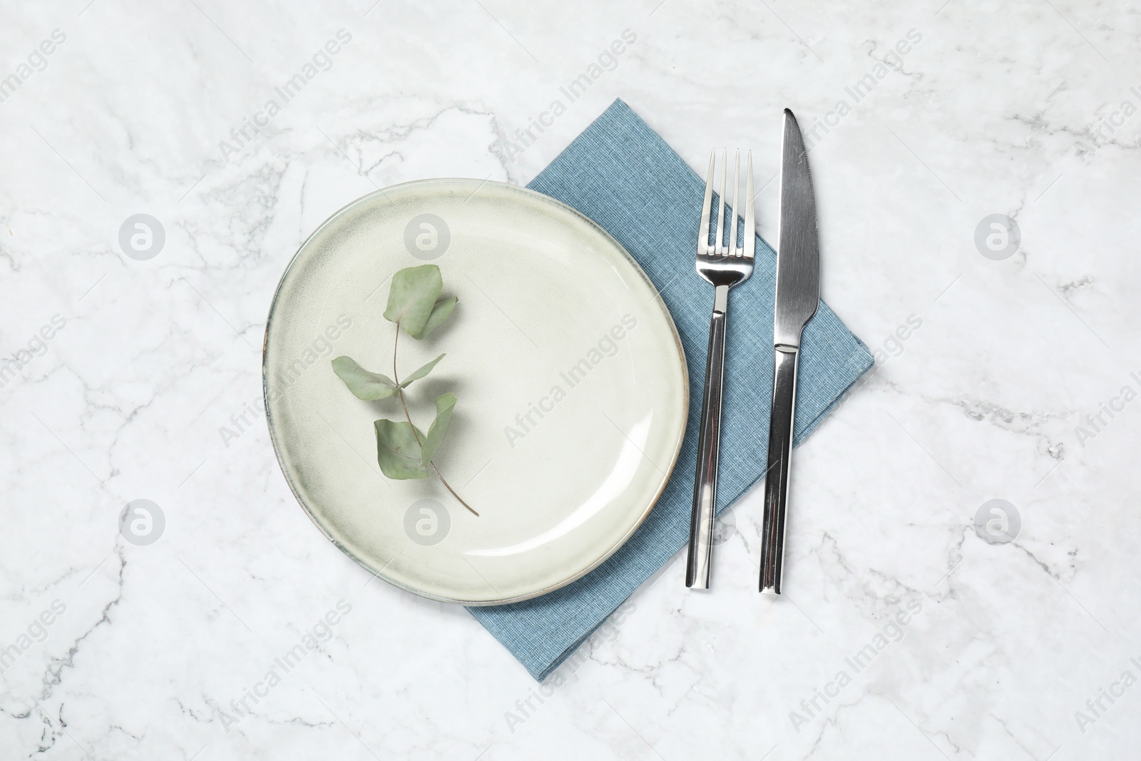 Photo of Stylish setting with elegant cutlery on white marble table, top view