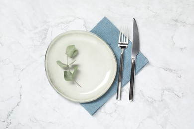 Stylish setting with elegant cutlery on white marble table, top view